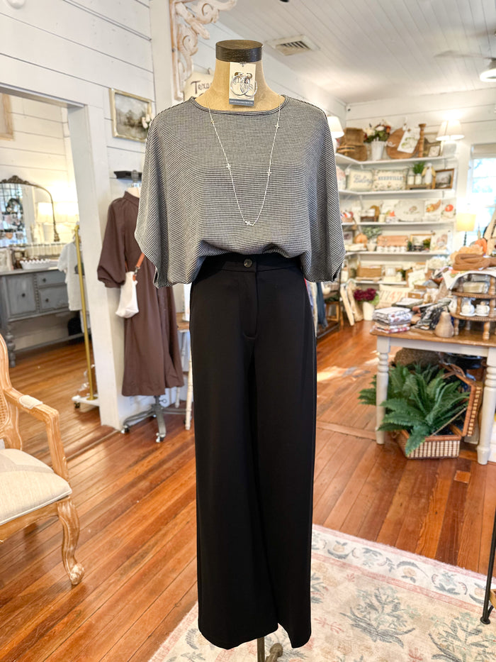 Mannequin wearing a black and white top and black pants in a store setting