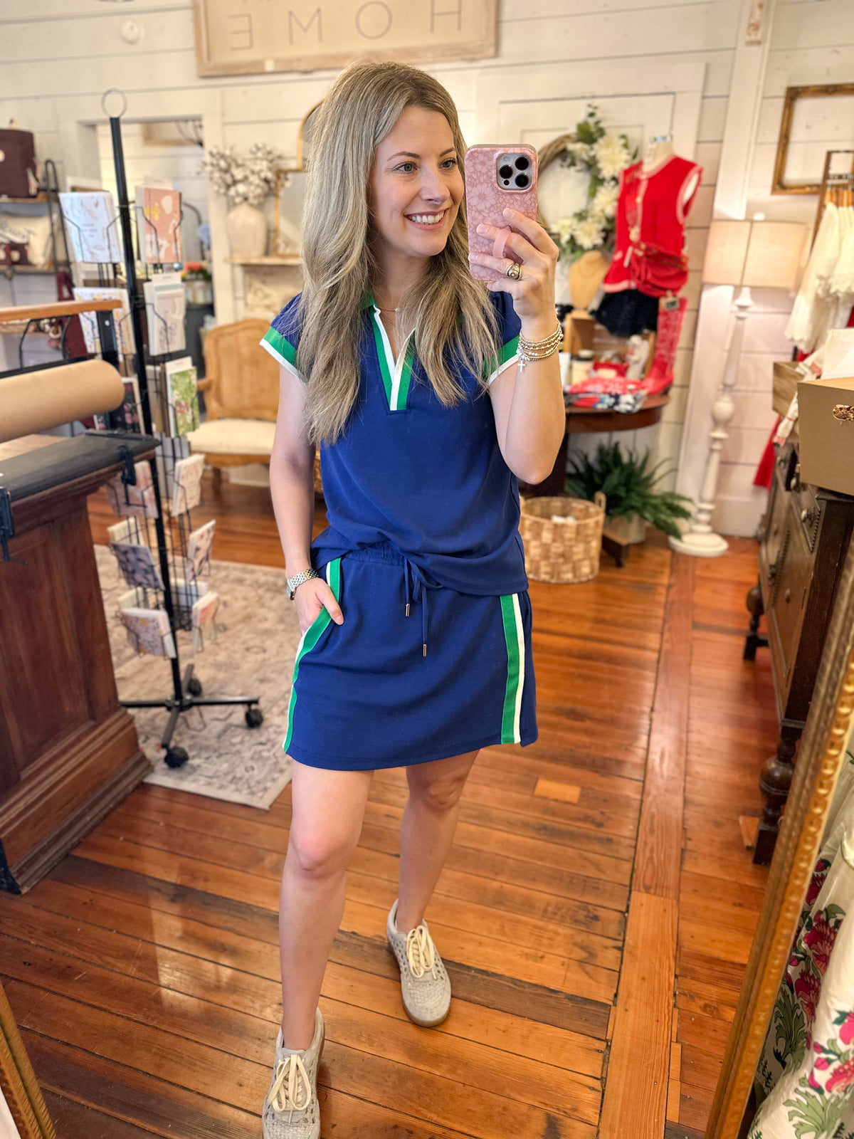 Woman taking a mirror selfie wearing a blue lounge set in a store.