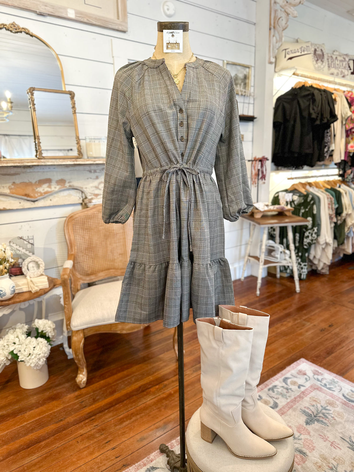 Plaid dress on a mannequin with white boots in a store setting