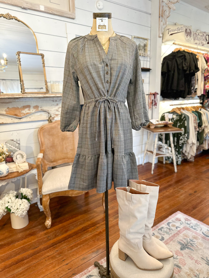 Plaid dress on a mannequin with white boots in a store setting