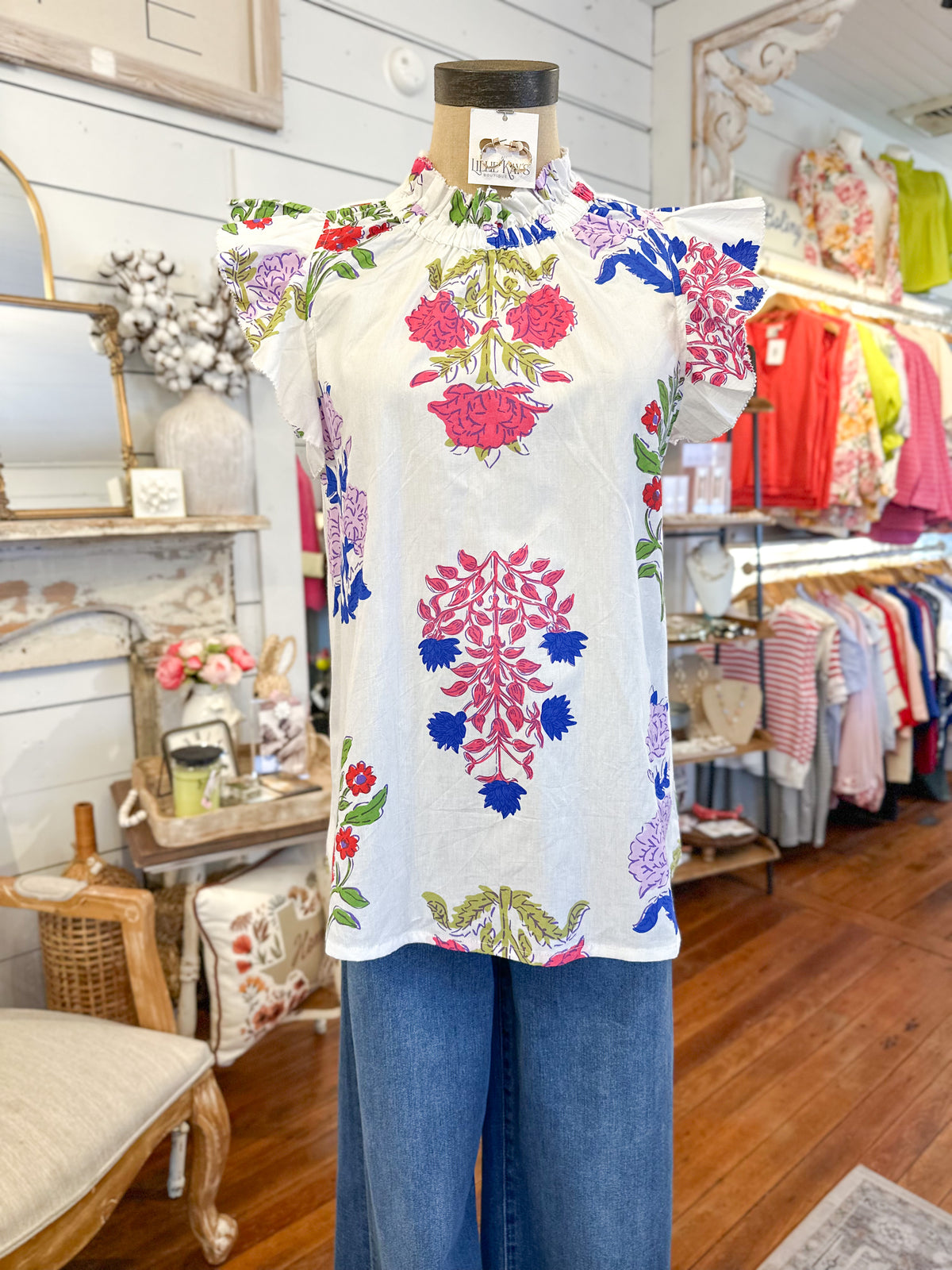 Mannequin wearing a floral top and blue pants in a store setting