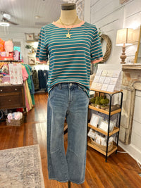 Mannequin wearing a striped shirt and jeans in a store setting