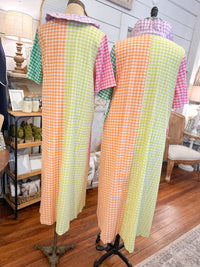 Two mannequins wearing colorful checkered dresses in a store setting.