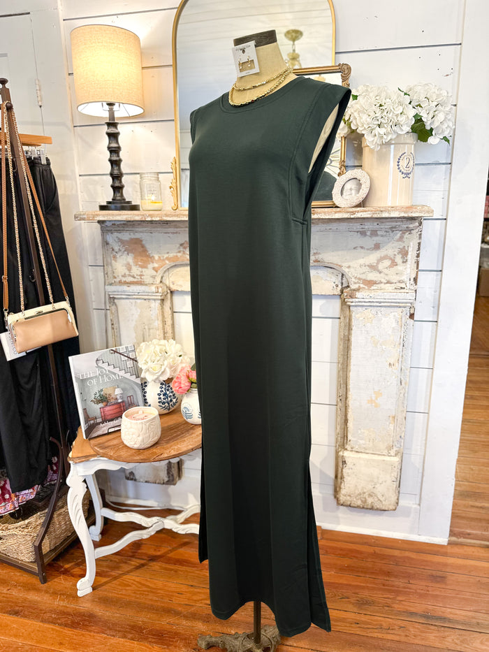 Green dress on a mannequin in a room with a fireplace and decor items.