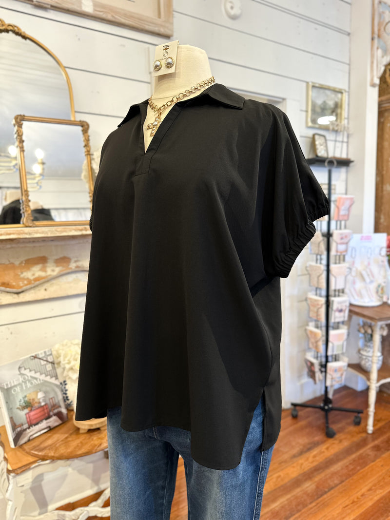 Black shirt on a mannequin with blue jeans in a store setting