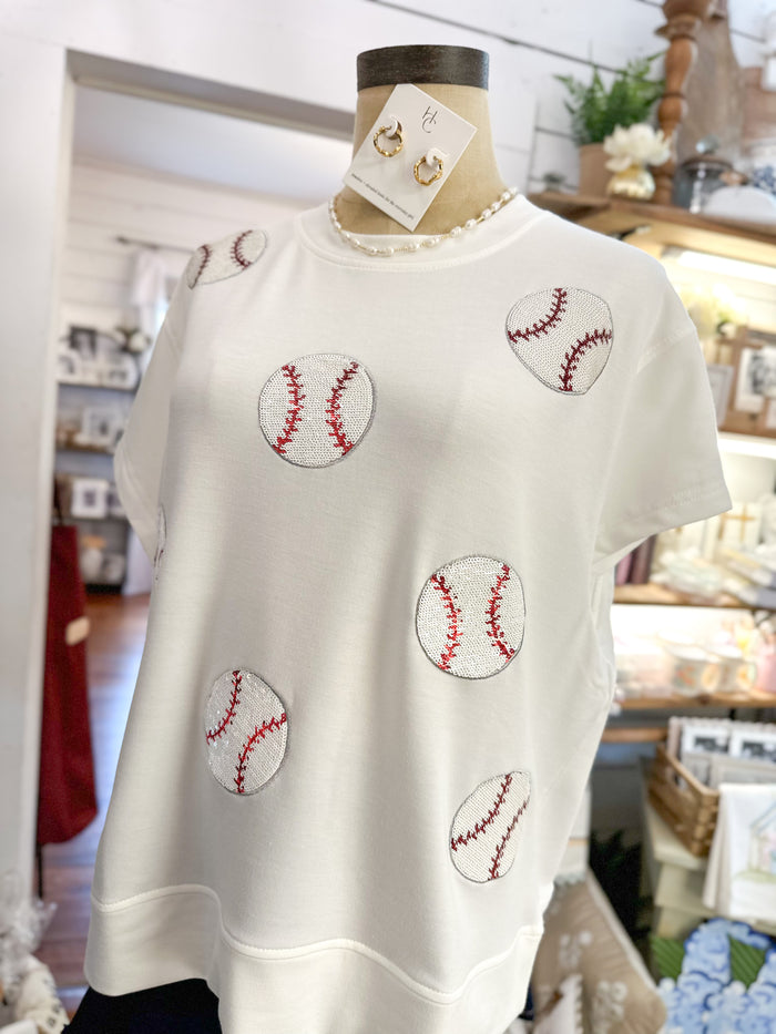 White t-shirt with baseball designs on a mannequin in a store setting