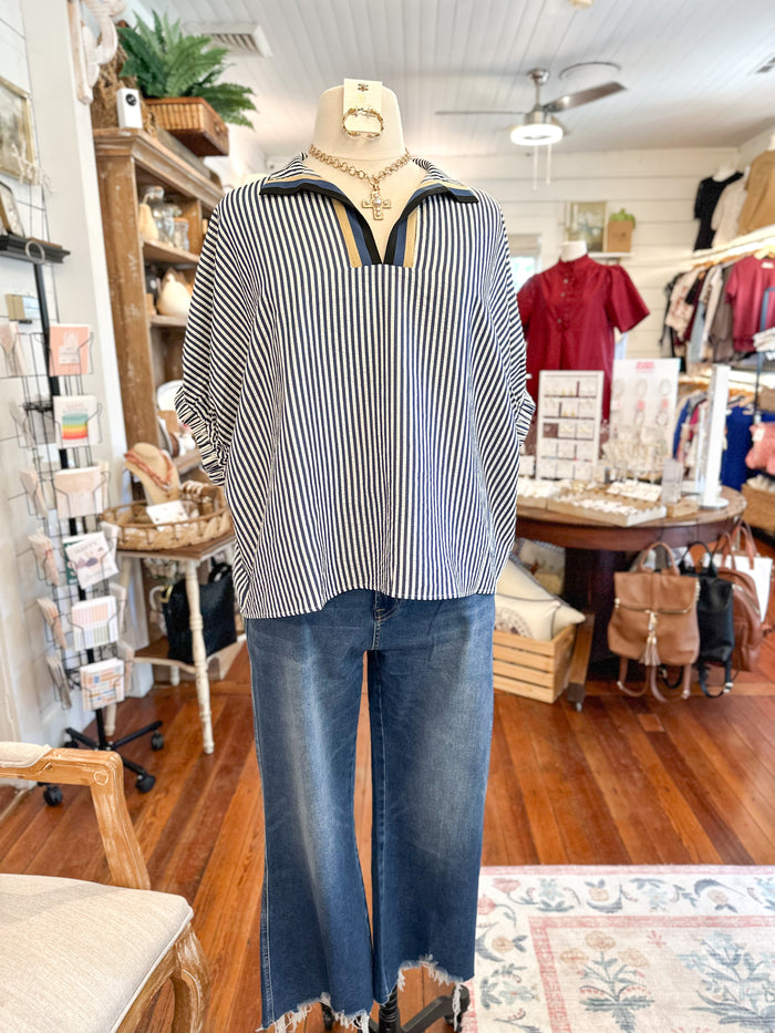 Mannequin wearing a striped shirt and jeans in a store setting