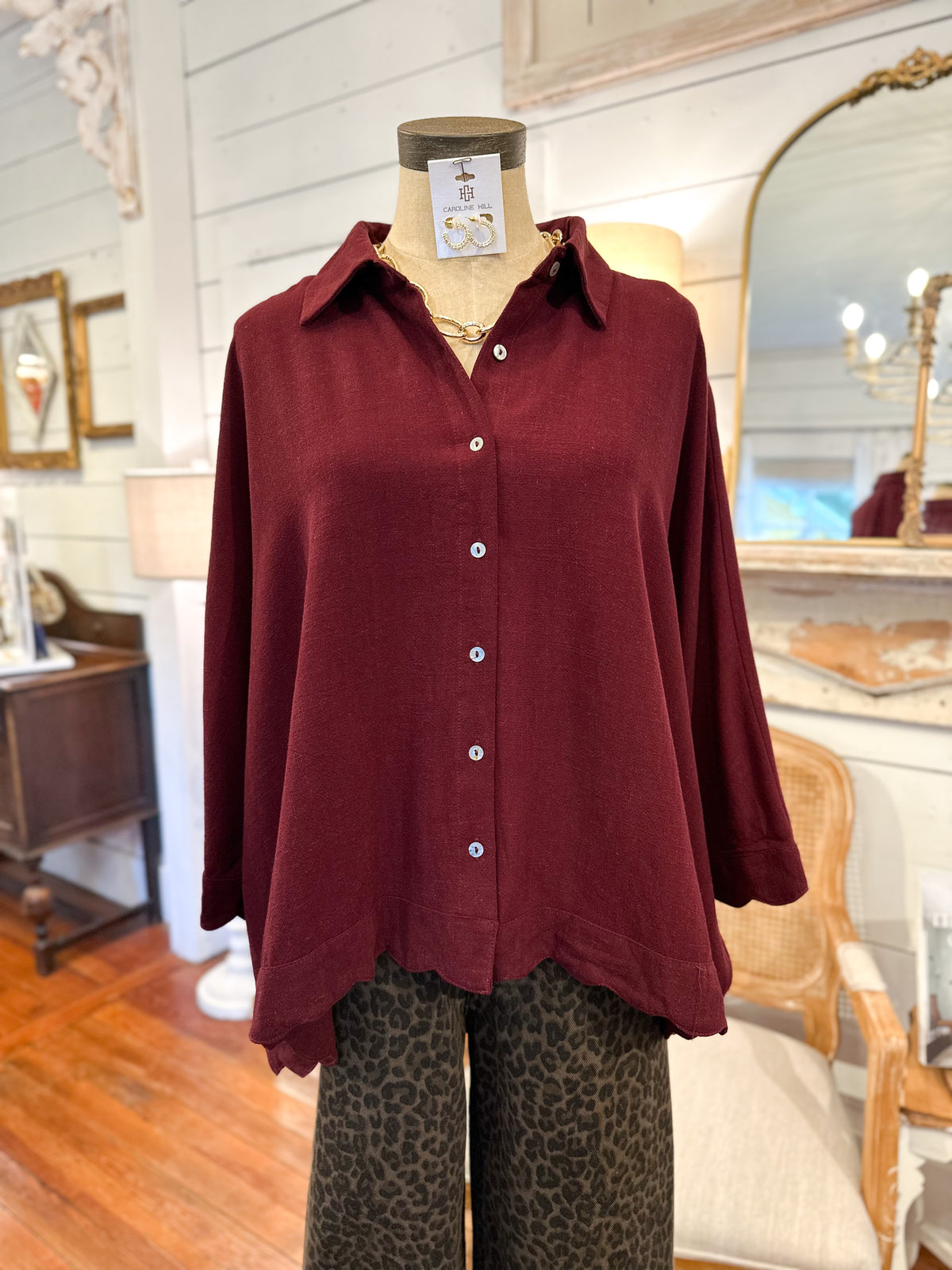 Mannequin wearing a burgundy linen blend top with leopard print pants in a store setting
