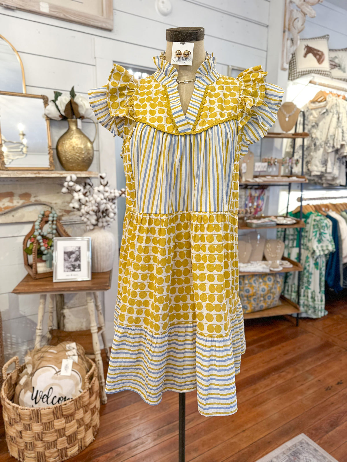 Yellow and blue patterned dress on a mannequin in a store setting.
