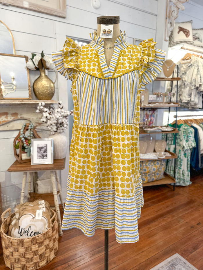Yellow and blue patterned dress on a mannequin in a store setting.