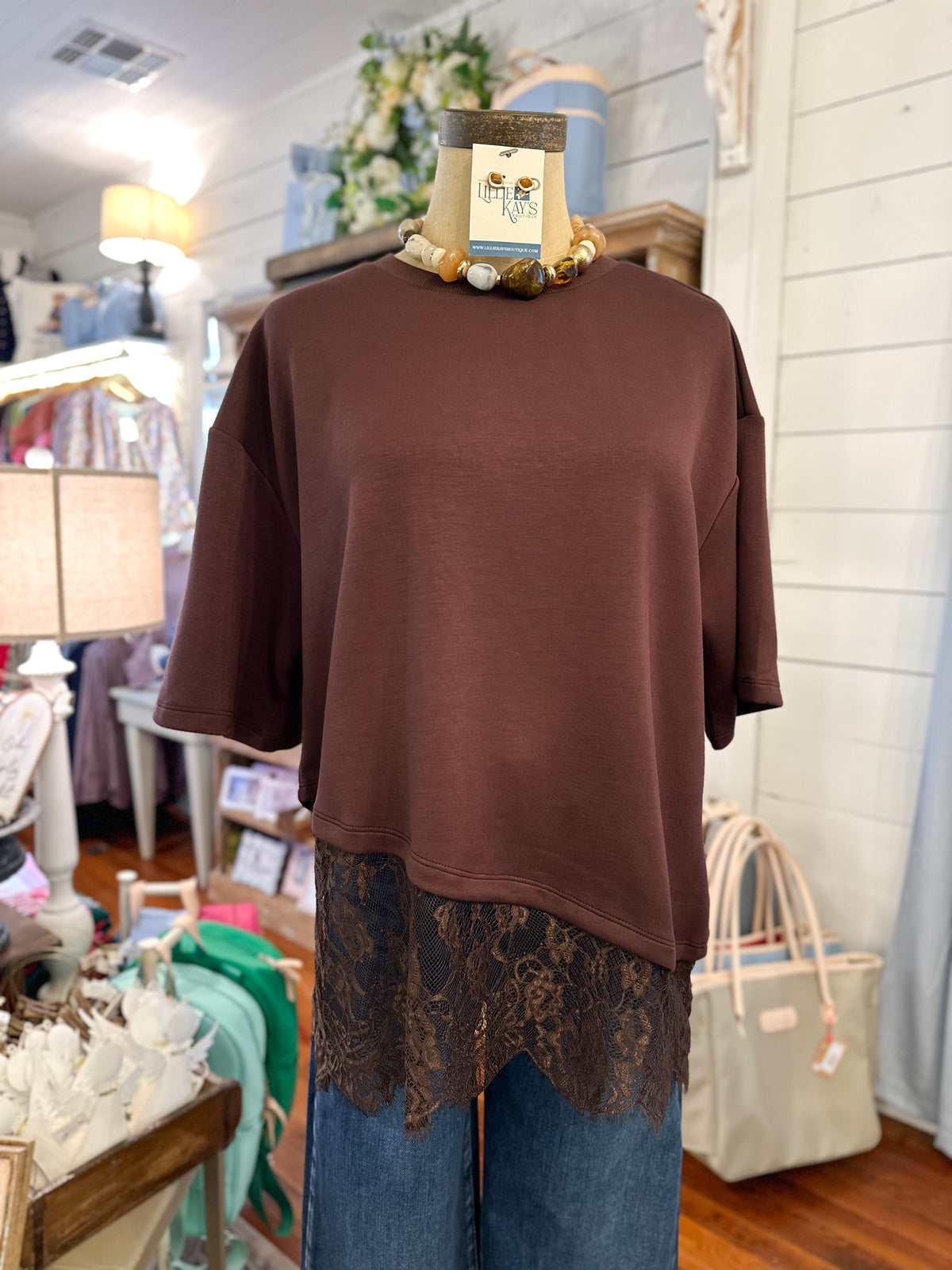 Chocolate brown short sleeve top with lace along hem of top 