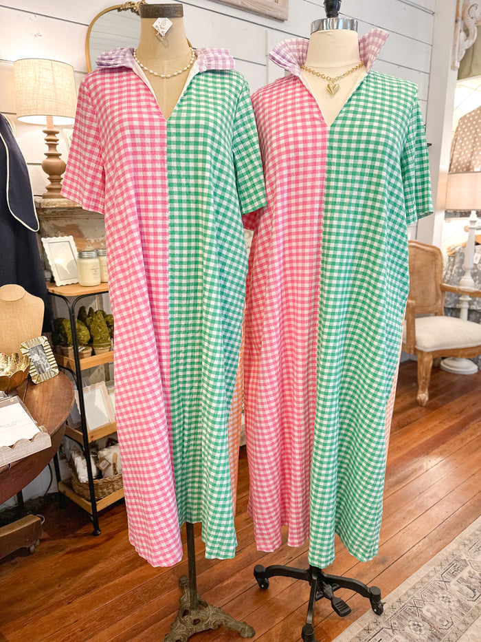 Two mannequins wearing pink and green checkered dresses in a store setting.