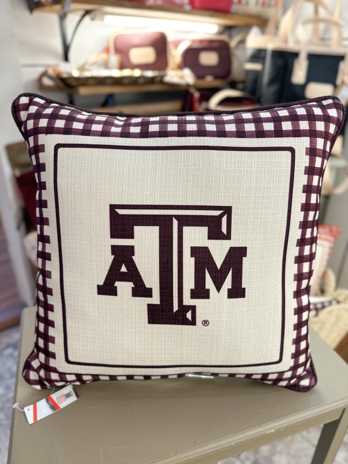 Decorative pillow with 'ATM' logo on a chair in a store setting