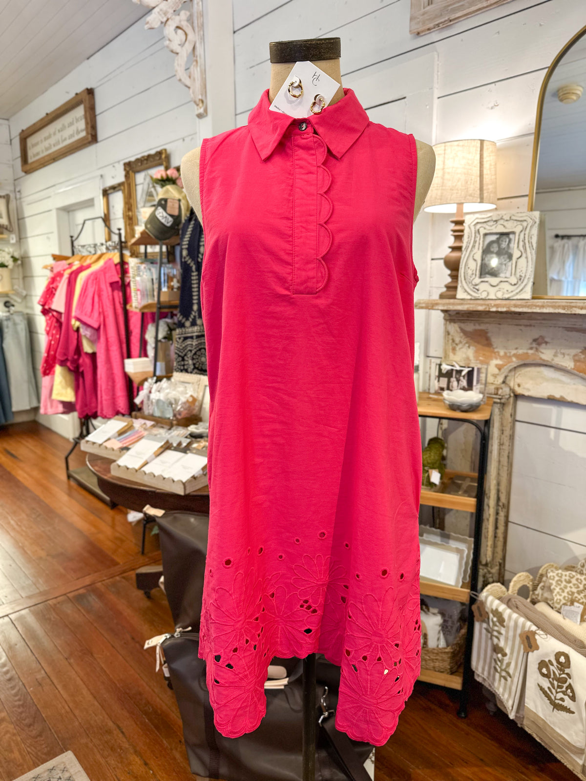 Mannequin wearing a bright pink sleeveless dress in a store setting.