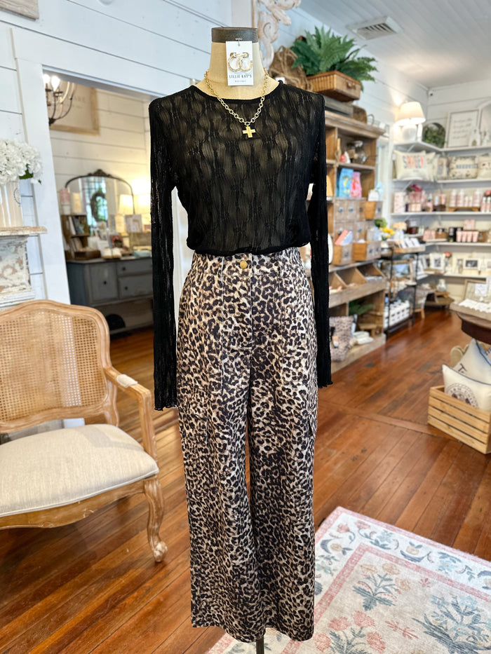 Mannequin wearing a black top and leopard print pants in a store setting