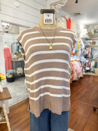 Mannequin wearing a brown and white striped sweater with a store interior background