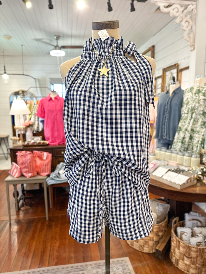 Mannequin wearing a blue and white checkered outfit in a store setting