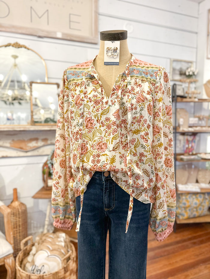 Mannequin wearing a floral blouse and jeans in a store setting