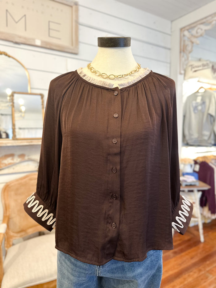 Brown blouse on a mannequin with a blurred store interior background