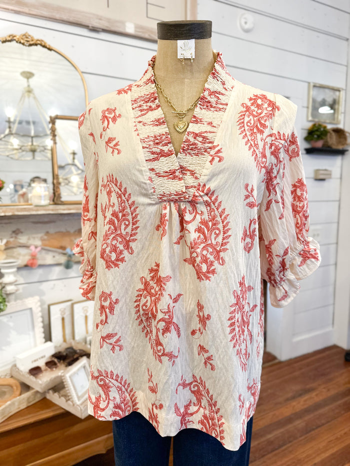 cream color short sleeve blouse with rust color paisley print 