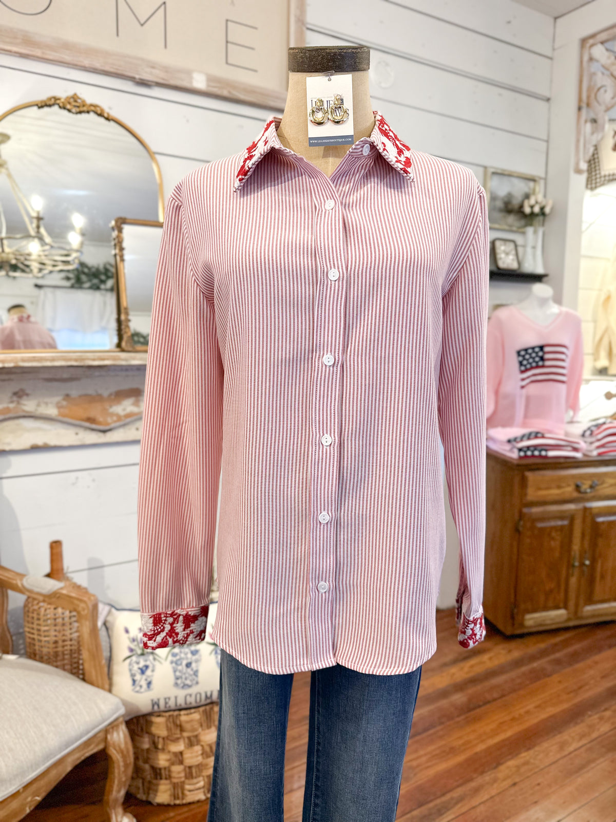 red striped shirt on a mannequin in a room with wooden floor and furniture.