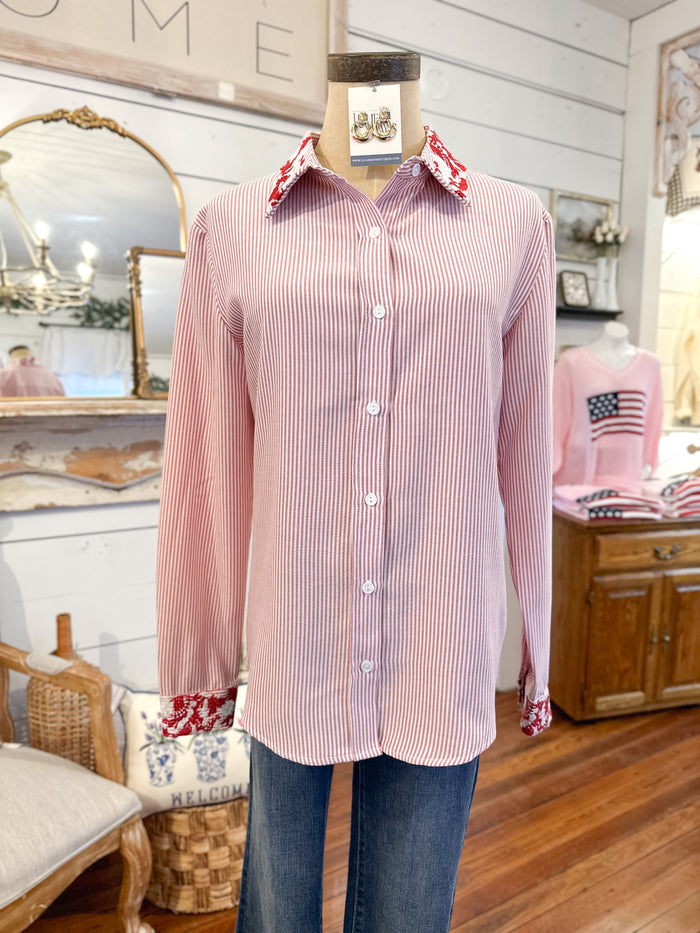 red striped shirt on a mannequin in a room with wooden floor and furniture.