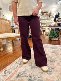 Person wearing maroon flared pants in a home setting