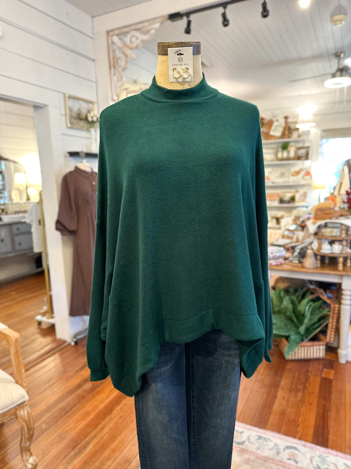 Green sweater on a mannequin in a store setting