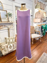 Purple dress on a mannequin in a store setting with various items in the background.