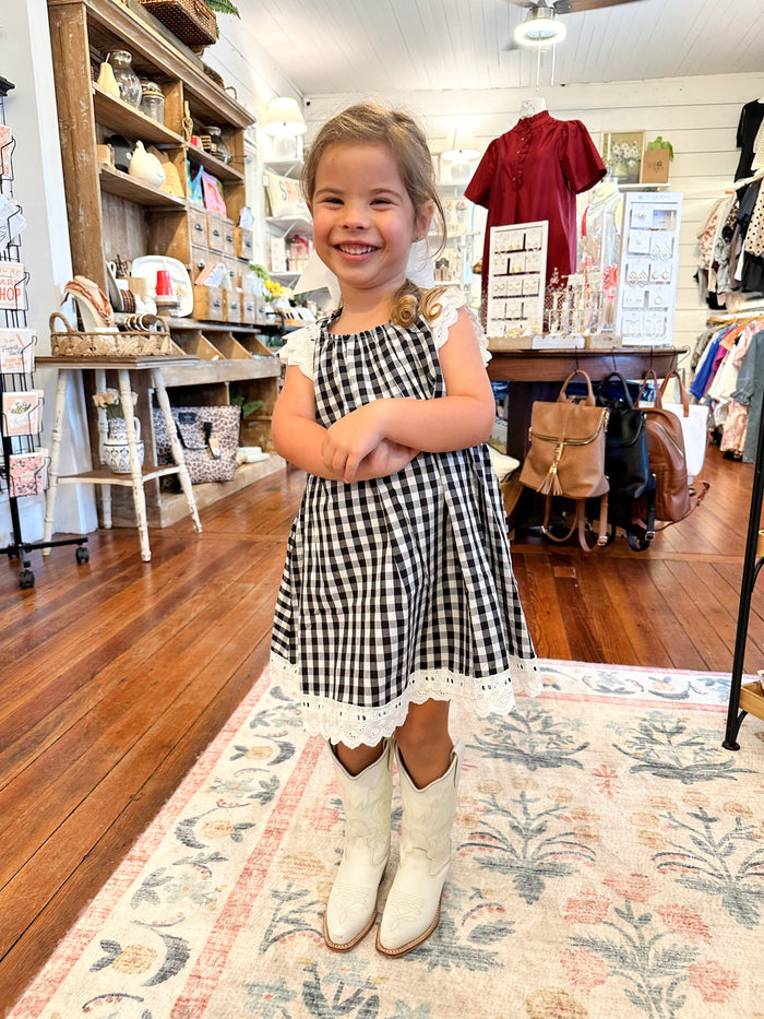 Little girl wearing black and white plaid dress 