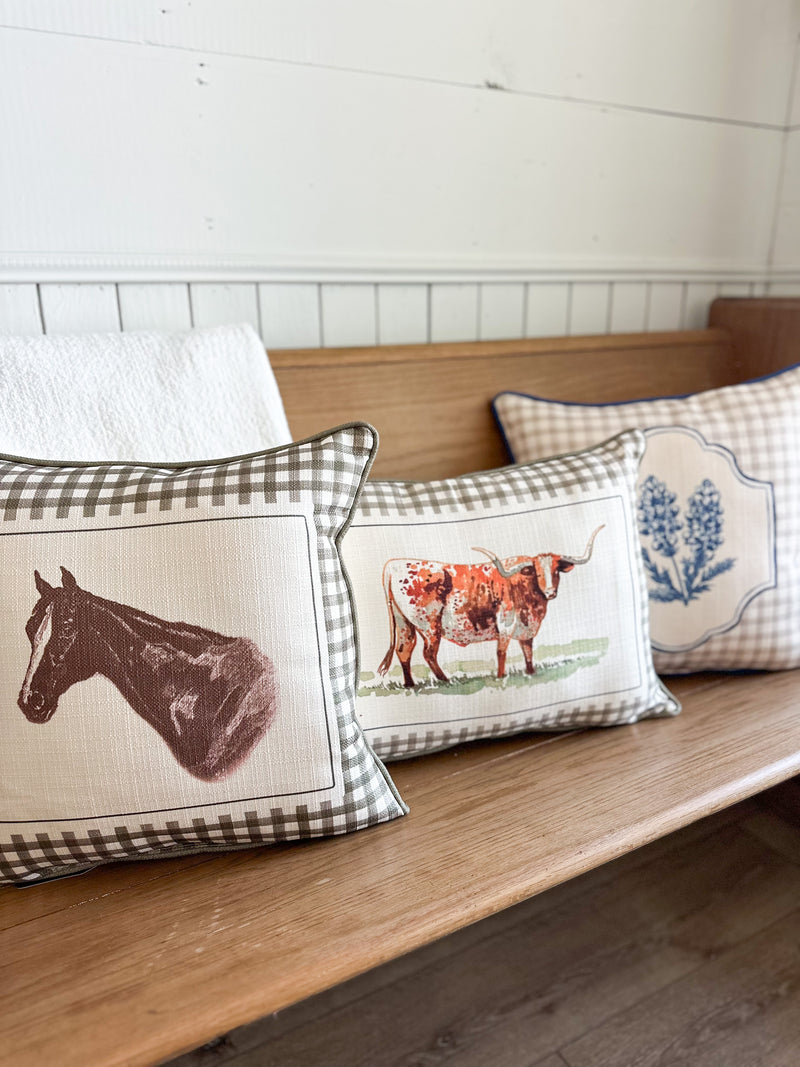 Decorative pillows with animal prints on a wooden bench.