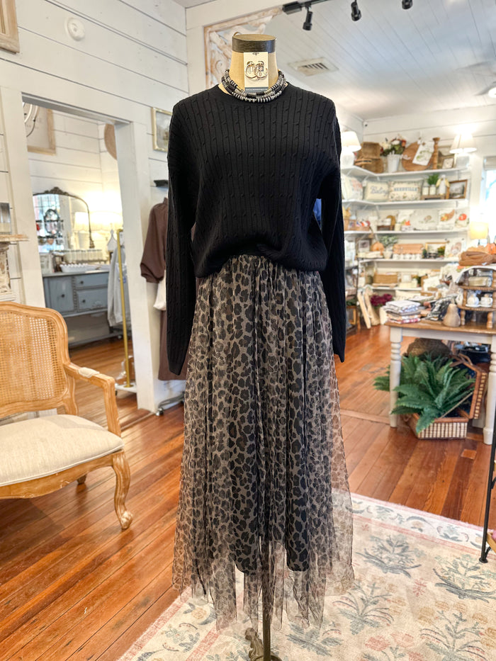 Mannequin wearing a black sweater and leopard print skirt in a store setting