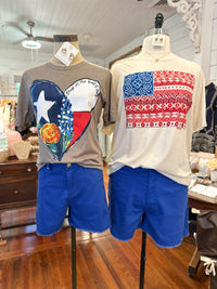 Two mannequins wearing shirts with Texas and American flag designs and blue shorts in a store setting.