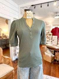 Green shirt on a mannequin in a store setting tanner top another love 