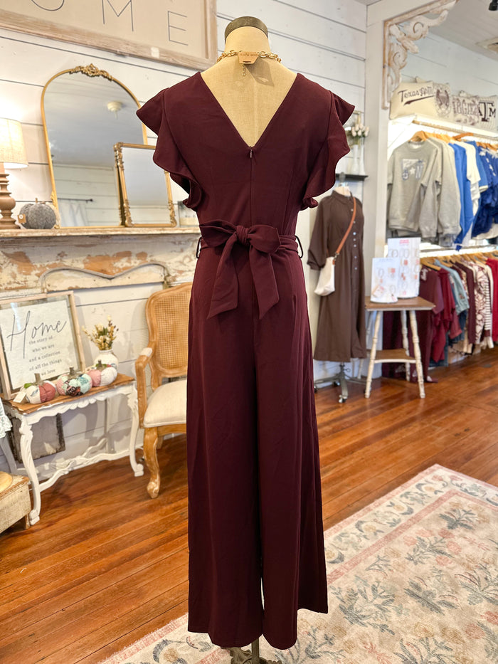 back of maroon pant jumpsuit inside store 