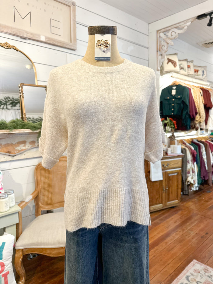 Mannequin wearing a beige sweater and blue jeans in a store setting