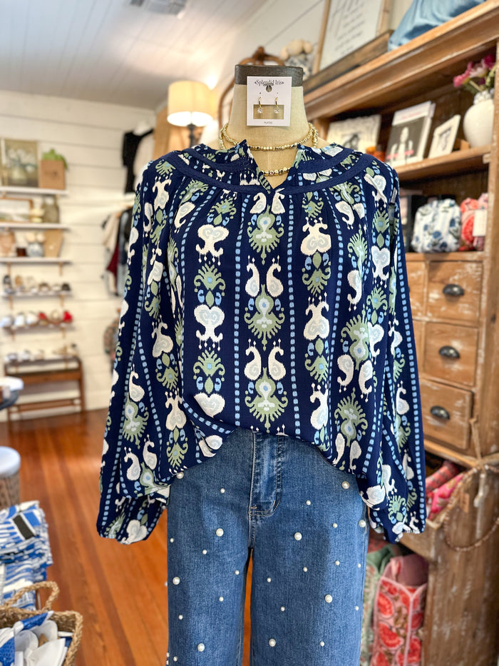 Mannequin wearing a blue patterned blouse and jeans in a store setting
