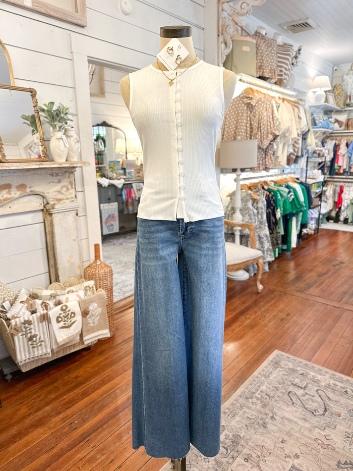 Mannequin wearing a white shirt and blue jeans in a store setting