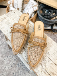 Pair of woven sandals with a bow on a wooden surface. corkys footwear 