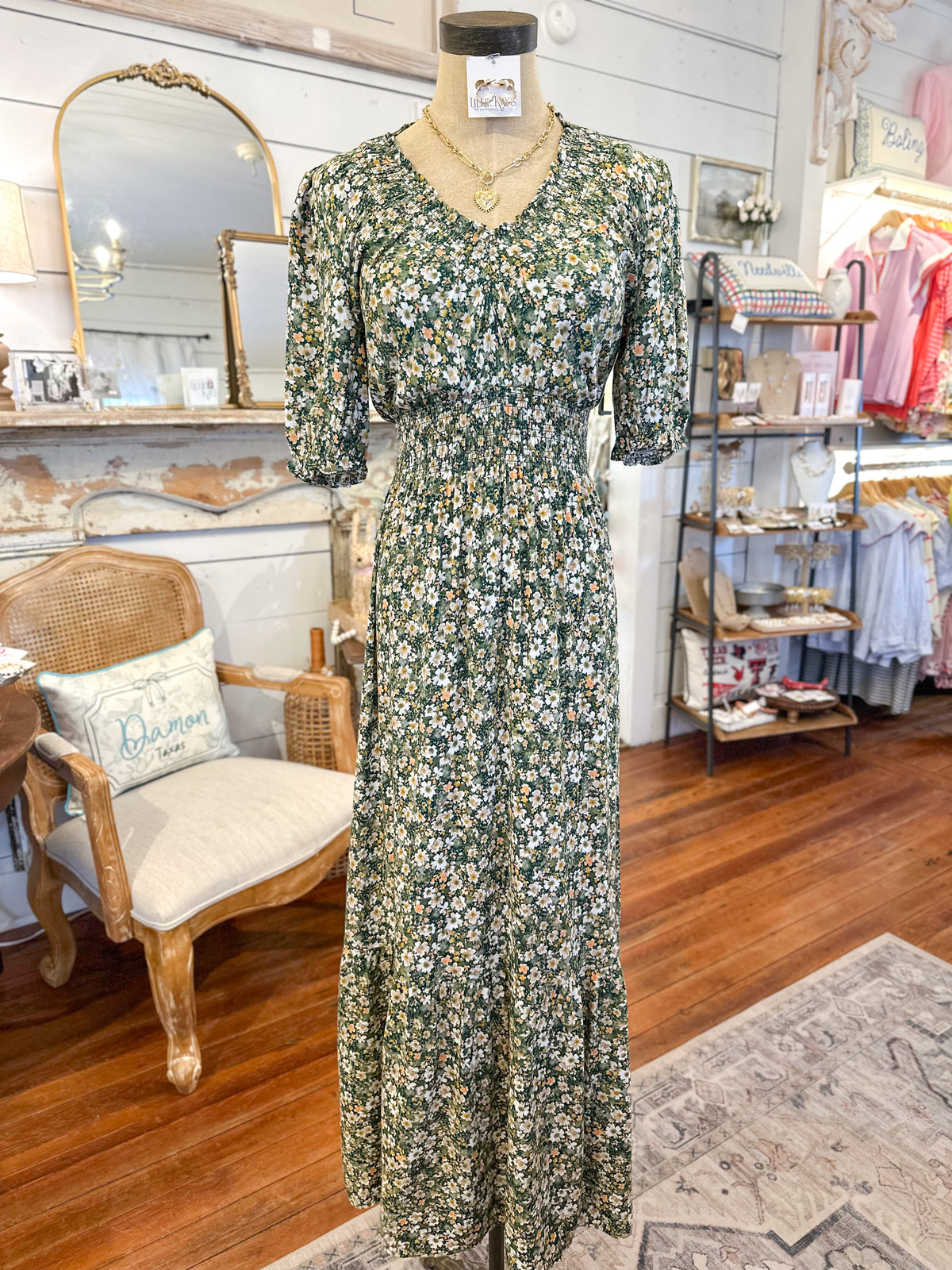 Floral dress on a mannequin in a store setting with furniture and decor.