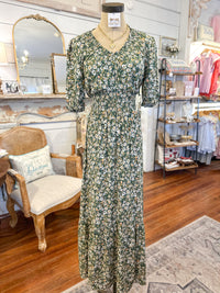 Floral dress on a mannequin in a store setting with furniture and decor.