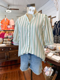 Mannequin wearing a striped shirt and denim shorts in a store setting
