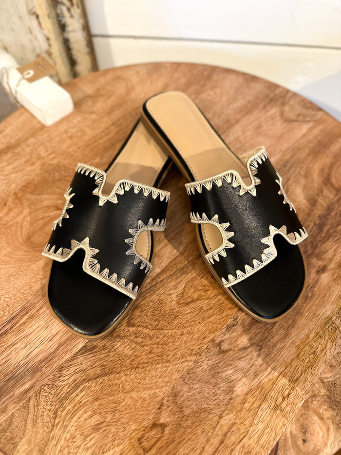 black sandals with cream color stitching 