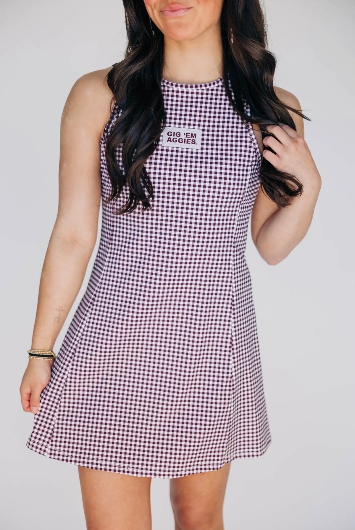 Woman wearing a checkered dress with text on a plain background