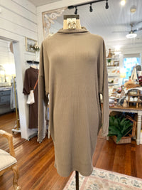 Beige ribbed sweater on a mannequin in a store setting