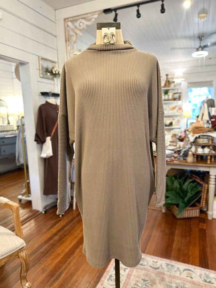 Beige ribbed sweater on a mannequin in a store setting