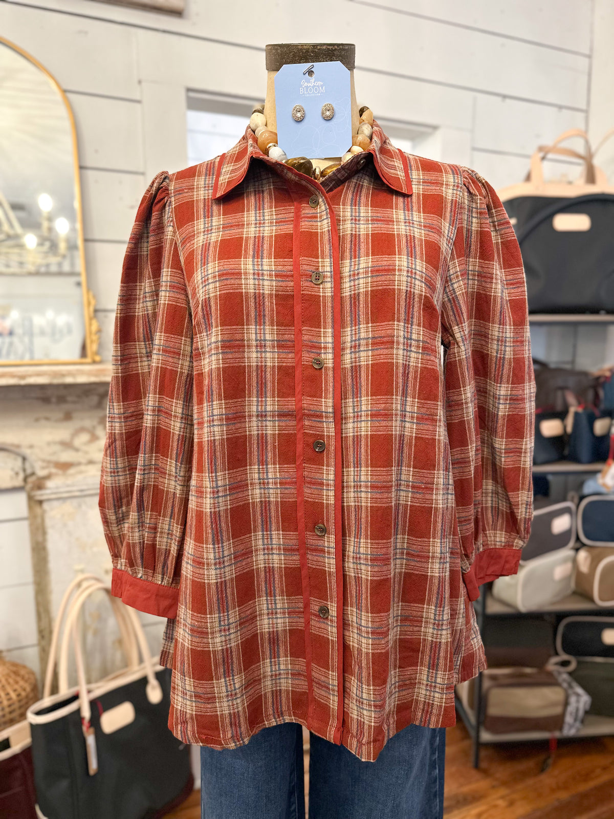 brick plaid button down blouse fall fashion inside store setting 
