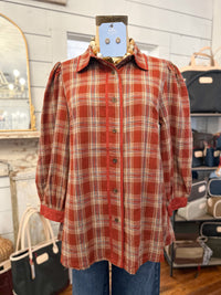 brick plaid button down blouse fall fashion inside store setting 