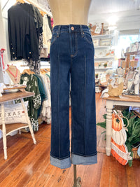 Blue jeans on a mannequin in a store setting with clothing and decor in the background
dear john holly jean 