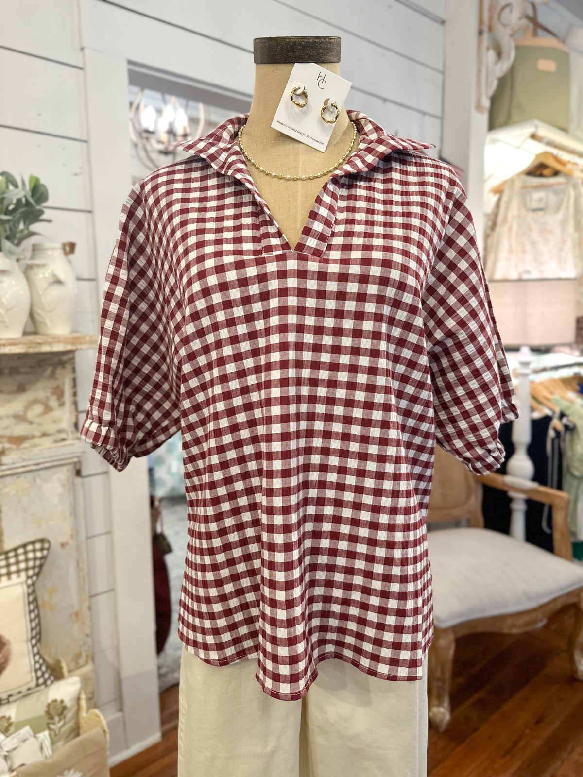 Maroon and white checkered shirt on a mannequin in a store setting
